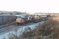 Looking very woebegone, and engineless, Loadhaul liveried 37710 (formerly D6744 and withdrawn in 2005) sits behind the workshops at Carnforth WCRC complex. Amongst the stock visible here are a steam loco tender, an industrial shunter, a crane and Brush Type 4 no 47776. <br><br>[Mark Bartlett 28/11/2010]