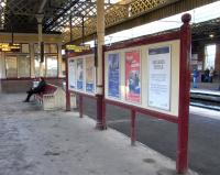 This poster board and bench on the central platforms at Gilmour Street look is if they are of the same, considerable vintage and it's pleasing that they have been allowed to survive. What posters that board must have seen. What... um... people the bench must have seen. The windows in the background always intrigue me: sash windows in what is essentially the open air. I am reminded of whoever it was who took a car door as his luxury on Desert Island Discs so that if it got too hot he could wind the window down. Photographed on 27 November 2010.<br>
<br><br>[David Panton 27/11/2010]