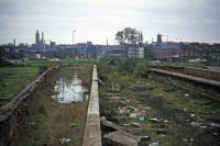 After final closure on 3rd February 1969, the ruins of Norwich City station disappeared in stages. First to go were the street facing structures, removed in the early 1970s when a new roundabout for the Norwich inner ring road encroached on the site. This view, taken in October 1976, is of the four truncated and excavated platforms looking towards the roundabout. It seems probable that the platform infill was used to shape the roundabout dome.<br><br>[Mark Dufton 23/10/1976]