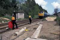 The level crossing at Ardleigh was converted from manual gates to automatic lifting barriers on April 24th 1983. Despite no working signals or track circuiting, the trains were kept running by basic signaling methods that dated back to the early years of railways. In this photo taken on that day, 47 431 heading a Norwich to London express is being flagged down for the driver to be assured that the line ahead was clear. I learned from a signalman some months later that there had been a miscommunication during this operation which had resulted in a narrow squeak.<br><br>[Mark Dufton 24/04/1983]