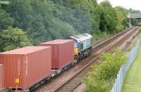 DRS 66410 takes the 12.56 Elderslie - Grangemouth containers north east towards Cumbernauld on 26 July 2006 having just passed the platforms of Greenfaulds station. <br><br>[John Furnevel 26/07/2006]