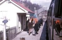 <I>Ah, look, there's the bus now...  you won't have much further to carry that heavy suitcase... </I>Transport interchange at Garve in the spring of 1971, with the Highland Omnibus service for Ullapool waiting alongside the platform.<br><br>[Frank Spaven Collection (Courtesy David Spaven) //1971]