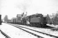The Langholm freight stands amid a wintry landscape as it prepares to leave the station pre-passenger closure in 1964. In charge is one of the Langholm branch 'regulars' at that time, Ivatt 2-6-0 no 43049 of Kingmoor shed.<br><br>[Robin Barbour Collection (Courtesy Bruce McCartney) //]