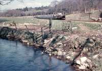 Running alongside its namesake, with a train for Ravenglass, is the Ravenglass and Eskdale's <I>River Mite</I>. This was the locomotive's first year in service and it is seen here near Muncaster Mill.<br><br>[David Hindle //1966]