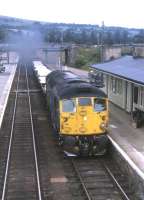 With a Class 26 in charge, aluminium blocks from the Invergordon smelter head south through Dingwall in the summer of 1973. <br><br>[David Spaven //1973]