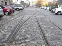 These rails ran parallel with the edge of Leith Old Dock (right) and the dockside warehouses on the left which are now chichi restaurants and shops.  Whether the cobbles (setts, in strictness) had to remain because of the rails or vice-versa I don't know - it depends on the timing - but it has resulted in a bit of unintended preservation. Photographed looking west in January 2011.<br><br>[David Panton 03/01/2011]