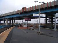 A look along the platform at Ruggy on 4 January. With construction <br>
workers still on their seasonal break all is quiet on the unfinished M74 extension above. There are passengers around, but they are sensibly in the heated ticket office behind me on this cold, damp January day.<br>
<br><br>[David Panton 04/01/2011]