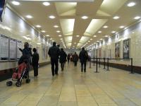 Although this corridor is on the same level as the main line station it is behind the ticket barrier for the Low Level lines. I'm standing at the top of the steps to Platform 9, eastbound. Platform 8 access is at the far end, opposite the ticket barrier. Passengers from an eastbound train make their way towards the exit, while a family standing below the departure board check a timetable poster. <br><br>[David Panton 04/01/2011]