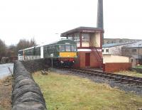 First ELR service of the day/year arrives at Rawtenstall running in over the level crossing past Rawtenstall West signalbox. There was a corresponding Rawtenstall East box that controlled the level crossing at the other end of the station but this was closed along with the Bacup line in December 1966. The 2-car Met Cam DMU was augmented by a Gloucester RC&W <I>bubble car</I> on this service. [See image 32793] <br><br>[Mark Bartlett 01/01/2011]