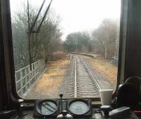 The widening trackbed indicates this was Stubbins Junction where the Accrington line diverged from that to Rawtenstall and Bacup, although the station platforms only served Bacup line trains. Stubbins' platforms have not seen a passenger for almost forty years now but are still extant as seen here looking north from the rear of a passing ELR DMU service. [See image 19681] for the same location thirty years earlier.<br><br>[Mark Bartlett 01/01/2011]