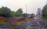 Looking towards the Connel Bridge with the former approach to Connel Ferry station behind the camera. This would have been the northern junction of a triangular layout at Connel had the west to north curve been installed [see image 29609] (this was railway No 2. in the Act of which only a road overbridge and some earthworks were built). <br><br>
<br><br>
What is below is in doubt - loading of the charabanc was carried out at the east facing bay platform at Connel Ferry station.<br><br>
<br><br>
Of particular interest in this shot is the old loading ramp. This ramp was used to load cars onto a rail mounted charabanc's trailer for a short haul over the viaduct. The charabanc operated a fairly intensive service - ten round trips a day from Connel Ferry to North Connel with four of these running on to Benderloch. This ran between 1909 and 1914. Beyond the ramp is the old hut from a later period following alterations to the bridge to allow cars to cross when not in use by trains. The charabanc is said to be the same one which provided a connecting service between Clarkston station and Eaglesham.<br><br>[Ewan Crawford //1990]