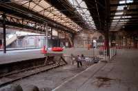 In 1987, before refurbishment by Railtrack, Greenock Central still featured a large glazed roof over the circulating area. The Gourock Extension platforms had canopies over them but not an overall roof, this having been cut back at an earlier date. The photograph was taken from the end of what must be one of the shortest platforms in the country. The view looks west with the Gourock platforms on the far left. Before the opening of the Gourock Extension the terminal platforms continued to a station on Cathcart Street, serving transatlantic ships via East Quay Lane. The circulating area shown here is now a car park. The Greenock Railway's locomotive shed and works was originally located in the area occupied by the Gourock platforms, resulting in the establishment of Greenock Ladyburn shed as a replacement.<br><br>[Ewan Crawford 19/09/1987]