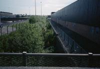 Under all the undergrowth the Shieldhall Goods Branch was still in place in 1987. This branch served several goods yards and the Alexander Stephens Shipyard at Linthouse. The branch was the genesis of the Glasgow and Renfrew District Railway which branched from it near Cardonald. The view looks to Cardonald from Renfrew Road bridge with part of the Govan sewage works on the left.<br><br>[Ewan Crawford 19/05/1987]