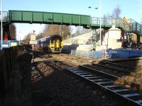 158906 runs slowly under the new footbridge at Woodlesford Station on the 12.05 ex Leeds fast service to Nottingham following the late running 12.08 Knottingley departure. The footbridge is to replace the existing boarded crossing seen forward of the DMU. [See image 30851] <br><br>[David Pesterfield 19/01/2011]