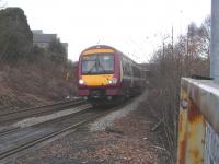 170 477 embarks on the climb form Inverkeithing station to the Forth <br>
Bridge with a Fife local on 22 January. The rear of the train is <br>
clearing the points at Inverkeithing South, the junction for the Rosyth Dockyard Branch. I wouldn't like to calculate what fraction of the time the points are set for the branch, but I can at least predict that the points motor is unlikely to wear out.<br>
<br><br>[David Panton 22/01/2011]