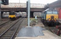 A reduced requirement for Thunderbirds has seen some Virgin Class 57s recently reported as stored but there is usually one on standby at Preston. Others are used on the Holyhead to Cardiff loco hauled passenger service. 57313, reliveried in <I>Neutral Blue</I>, is in the short siding at the north end of Platform 3 as 150146 runs in to Platform 2 on a Blackpool to Liverpool service.<br><br>[Mark Bartlett 26/01/2011]