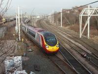 Until the December 2012 timetable change several WCML trains from Euston terminated at Lancaster and then ran ECS to Carnforth before returning to London. Pendolino 390015 <I>Virgin Crusader</I> arrived at Lancaster at 1500 and is seen here rejoining the main line, after a brief layover in a Carnforth loop, running ECS to form the 1539 Lancaster to Euston. With the introductionof the hourly Euston - Glasgow services these Carnforth manoeuvres have now stopped.<br><br>[Mark Bartlett 01/02/2011]