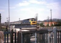 A class 47 about to take a Paddington bound train over Silk Mill level crossing just east of Norton Fitzwarren station at Easter time in 1981. [With thanks to David Prescott, Ian Mackie and Jim Watson] [See image 32631]<br><br>[John McIntyre //1981]