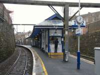 The island platform at Crosshill, looking towards Glasgow at spot on 1 o'clock, Saturday 5 February. A young man buys a ticket at the al-fresco ticket window while speaking on his mobile. How rude. Saying 'young man' and berating modern manners? I must be getting old; shoot me if I get worse. <br>
<br><br>[David Panton 05/02/2011]