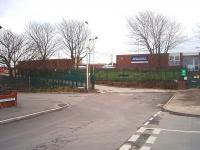 The entrance to Blackpool Train Maintenance Depot (TOPS Depot Code BP) is not particularly imposing. It is in the middle of a residential area of Blackpool and the depot accommodation comprises the two low roof buildings seen here at the top of the ramp. The depot rarely sees stock during the daytime but a number of DMUs are serviced here overnight and the overhead lighting of the carriage sidings can be seen behind the buildings. The sidings themselves are directly alongside the main running lines just outside Blackpool North station [See image 32554].<br><br>[Mark Bartlett 27/01/2011]