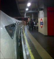 There's not much action in Acton when it's dark and persisting down with rain. The camera is looking East towards Hammersmith on 16 January, but the Piccadilly line train is heading for Heathrow.<br><br>[Ken Strachan 16/01/2011]