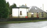 Originally opened by the Leadburn, Linton and Dolphinton Railway in 1864 as West Linton, the name change to Broomlee occurred in the late 1880s. The station nonetheless continued to be described in timetables as 'Broomlee for West Linton' until its closure in April 1933. The view is south west over the site of the level crossing on the B7059 (Station Road) to the east of the village in December 2004 with the platform on the left and the now 'filled-in' canopy area clearly discernible.<br><br>[John Furnevel 05/12/2004]