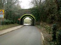 The twin arches of the former railway bridges to the north of the station site at Woodford Halse have their safety markings lit up by the setting sun on 4 February 2011. Figuratively speaking, the sun set on the Great Central some 43 years ago.<br><br>[Ken Strachan 04/02/2011]