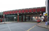 A street level view of Salford Central station on 19 February 2011. The glass encased area on the left below the overbridges is the spacious concourse which contains a booking office. Of the three overbridges which have been smartly painted, the furthest away carries the two tracks which serve platforms 1 and 2. The middle bridge once carried two tracks, each with platforms, but is now empty. The nearest bridge used to carry 4 tracks from Deal St Jn on the route to Ordsall Jn but this has now been reduced to two <br>
tracks. [See image 32888]<br>
<br><br>[John McIntyre 19/02/2011]