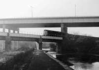 The pick up goods from Southport draws to a halt at Gathurst for 25105 to shunt the gunpowder wagons [See image 21338]. At this time traffic was conveyed for Southport Coal Depot, an MOD site at Burscough Junction and the explosives factory here. BR Type 2 25105 is heading east and has just passed under the M6 Motorway viaduct before crossing the part frozen Leeds Liverpool canal. <br><br>[Mark Bartlett 28/11/1978]