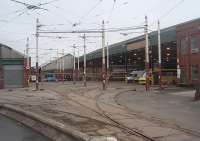 <I>Where is that wiring diagram?</I>. The entrance to Rigby Road tram depot has some intricate overhead catenary and pointwork. As the tramway is closed for another round of winter refurbishment the depot has been temporarily fenced off as seen here. Although the depot is know as Rigby Road, because that is where the main office is situated, the trams actually enter the depot along Hopton Road from Lytham Road. In this view in Hopton Road the line leading off to the left is the rarely used but still maintained and electrified emergency access route that approaches along Blundell Street and Princess Street. <br><br>[Mark Bartlett 20/02/2011]