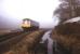Branch railcar at Terras level crossing on the Looe branch, on a misty morning in 1992. The channel of water on the right is the sea lock of the Liskeard and Looe Union Canal.<br><br>[Ian Dinmore //1992]