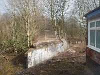 Whittingham Hospital passenger station was accessed by a flight of steps that climbed up the left hand side of the bridge abutment seen here. The station was a small but ornate structure with a glass canopy and screens but closed in 1957 and all that remains are a few concrete blocks that used to support the platform and some crumbling brickwork around the old waiting area. Only goods trains continued over the bridge into the hospital yard [See image 33027]. View towards Grimsargh from alongside the old railway weighbridge office at the yard entrance. Photo taken with kind permission of NHS staff. <br><br>[Mark Bartlett 03/03/2011]