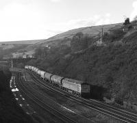 Class 47 no 47285 approaching Marsden Station on the Standedge route in the summer of 1983 with an eastbound blockload of bogie oil tanks, most likely returning empty to Tees-side.<br><br>[Bill Jamieson //1983]