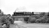 Stanier 8F 2-8-0 no 48151 photographed crossing the bridge over the A303 at Weyhill station site on the MSWJR branch from Andover to Ludgershall on 10 July 1988.<br><br>[Peter Todd 10/07/1988]