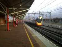 There's a nice echo of the red and yellow Pendolino livery in the platform awning support and ubiquitous yellow platform line at Rugby on 11 February. The train is heading North on the through line.<br><br>[Ken Strachan 11/02/2011]