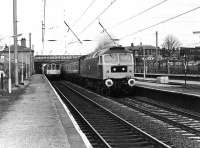 Brush Type 4 47555 <I>The Commonwealth Spirit</I> always seemed to be kept in good condition and is seen here passing through Leyland, with silver buffer embellishments, on a passenger train that is taking the Up Slow line. A BRCW three car Class 104 DMU has called at the Down Slow platform with a Manchester to Blackpool service. The Class 47 was in service for a further 19 years but withdrawn in 1999 and dismantled the same year at Springs Branch Component Recovery Centre in Wigan. <br><br>[Mark Bartlett 03/12/1980]