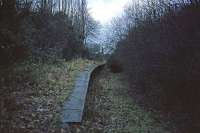 Derelict and ruined stations evoke a variety of sentiments, but in January 1976, the remains of White Colne station had the chilling feel of a forgotten grave. In life, the station had served passenger trains on the highly individual Colne Valley and Halstead line between Chappel & Wakes Colne and Haverhill. The waiting room was an old carriage body and the booking office was at the opposite end on the other side of a level crossing. The passenger service ended in December 1961 and the last freight train ran through from Halstead in 1965.<br><br>[Mark Dufton 10/01/1976]