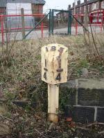 The 185 1/4 mile post, indicating distance from St. Pancras along the former Midland mainline route via Royston, is now located a significant distance from the current operational running line on the up side, being sited by a former siding end wall at the rear of the area now comprising the west end of Normanton station car park. The station access road can be seen beyond.<br><br>[David Pesterfield 17/03/2011]