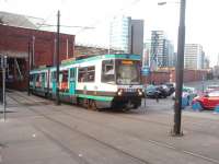 A Bury to Piccadilly service emerges from the <I>Hole in the Wall</I> at Manchester Victoria station to climb up to Shudehill. Trams from Bury arrive in the area that used to hold the bay platforms for the electric trains but then swing right through 90 degrees and leave the trainshed by this gap specially created for them to join the street running section. <br><br>[Mark Bartlett 19/03/2011]