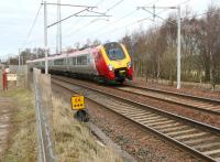 The 12.00 Glasgow Central - Birmingham New Street Virgin Voyager runs south through the site of Symington station (closed 1965) on 21 March 2011. The former goods yard and the trackbed of the cross country route to Peebles can still be made out on the east side of the line.<br><br>[John Furnevel 21/03/2011]