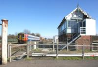 Sleaford West signalbox stands guard over the level crossing on 18 March 2011 as a westbound service heads towards Grantham and Nottingham.<br>
<br><br>[John McIntyre 18/03/2011]