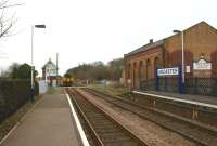 An East Midlands Skegness - Nottingham service seen running through Ancaster station, west of Sleaford, on 18 March 2011. 156401 has just passed over a minor road crossing alongside Ancaster signalbox. The former goods shed on the right is now in use as a furniture and kitchen workshop.<br>
<br><br>[John McIntyre 18/03/2011]