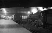 Night scene at Carlisle looking north along platform 3 in the early 1960s, featuring mounds of mailbags, eerily deserted platforms and BR Standard class 5 4-6-0 no 73009 standing quietly on the centre road. <br><br>[Robin Barbour Collection (Courtesy Bruce McCartney) //]