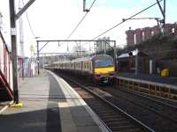 320 306 calls at the Glasgow-bound platform (which seems to need <br>
propping-up) at Duke Street on 26 March. The train has come all of 600 yards from its last stop, Alexandra Parade. There are two other pairs of stations in Scotland only 27 chains apart. If you know which they are your knowledge must be its own reward. The red silos to the right contain flour for British Bakeries which makes bread for the RHM group.<br><br>[David Panton 26/03/2011]