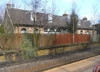 The station building at Crookston suffered a serious fire one night <br>
during the 7 years when the line was closed. Happily it was rescued by conversion into housing. It sits on the now disused platform: Glasgow to Paisley Canal trains in both directions have used the former westbound platform since reopening of the line in 1990. Stout fencing (aided by some self-seeded trees) gives residents some privacy from waiting passengers with nothing else to stare at. The fact that it is a hindrance to photographing this attractive building is of course a comparative irrelevance.<br><br>[David Panton 26/03/2011]