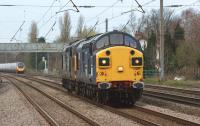 A pair of DRS Class 37s heading south light engine to Crewe passing Euxton on 31 March 2011 with 37087 leading 37218. In the background a northbound Virgin Pendolino is approaching Euxton Junction.<br><br>[John McIntyre 31/03/2011]