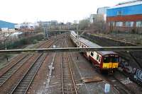 An outer circle service takes the Cathcart Circle at Muirhouse North Junction and prepares to stop at Pollokshields East. The two used tracks to the left are the route to Barrhead and Kilmarnock and the disused single track further left is the remains of the C.E. Yard (formerly carriage sidings and once a timber yard). March 2011.<br>
<br><br>[Ewan Crawford 27/03/2011]