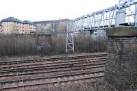 Two piers which supported the signal gantry at Muirhouse Central Junction still stand. Here the Cathcart Circle (two closest lines) leave the route to Barrhead. The view looks east in March of 2011.<br/><br/>Sitting comfortably? Here goes.<br/>The first line on the ground here was the General Terminus line of 1849 (in particular the Terminus Junction to Strathbungo Junction curve). This was followed 30 years later by the approach to the new Glasgow Central terminus (this met the General Terminus line beside the distant pier seen here). Finally in 1894 the Cathcart branch was extended from Cathcart west through Maxwell Park to Muirhouse Central Junction to form a 'circle'. At the same time a short connection was made between Muirhouse Central Junction and Muirhouse North Junction (old) to allow access to Glasgow Central. As a result there was a short section of quadruple track between the old Muirhouse North and old Muirhouse South junctions, a feature arising from the order of openings, but this no longer exists. The lifted section was running off to the left here, in line with the further away pier. The junction names have been re-used for what were Cathcart Junction (later renamed Pollokshields East Junction on opening of the Lanarkshire and Ayrshire Railway to save confusion) and Strathbungo Junction respectively.<br><br>[Ewan Crawford 27/03/2011]