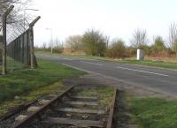 Looking south west across the A919 towards Leuchars North Junction in April 2011 from the boundary with RAF Leuchars. The main line runs just beyond the vegetation and Leuchars station is a few hundred yards to the left. Behind the camera is a fence and MOD property and, of course, unwise to photograph without permission but it's safe to report that if this view gives the impression that there's lots of track behind the camera then it's illusory as there's none at all! This was the start of the Tayport Loop which lost its passenger services through Leuchars (Old) station as long ago as 1921, though the connection with RAF Leuchars survived until the early 1990s. [See image 15388]<br><br>[David Panton 09/04/2011]