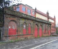 The shored-up facade of Glasgow Green station photographed on 13 <br>
April 2011. The station, which closed in 1953, was in a gap between tunnels so the white-tiled remains at platform level can easily be seen from a passing train on the Argyle Line today. Glasgow Green is now served by Bridgeton station less than half a mile upline. The rather understated building in the background here is the former Templeton's carpet factory. [See image 50115]<br><br>[David Panton 13/04/2011]